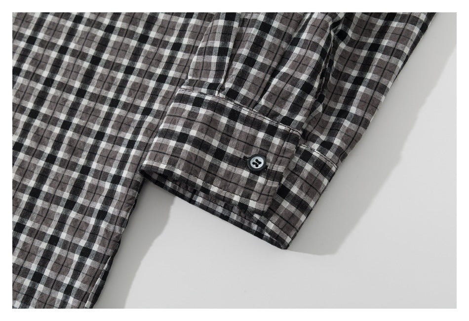 Close-up of a plaid shirt sleeve and buttoned cuff.