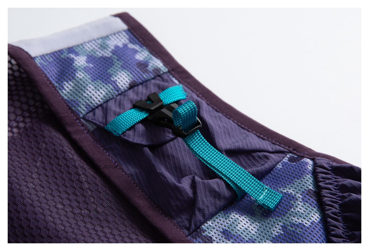 Close-up of a black buckle and turquoise webbing strap on a purple vest with patterned mesh panels.