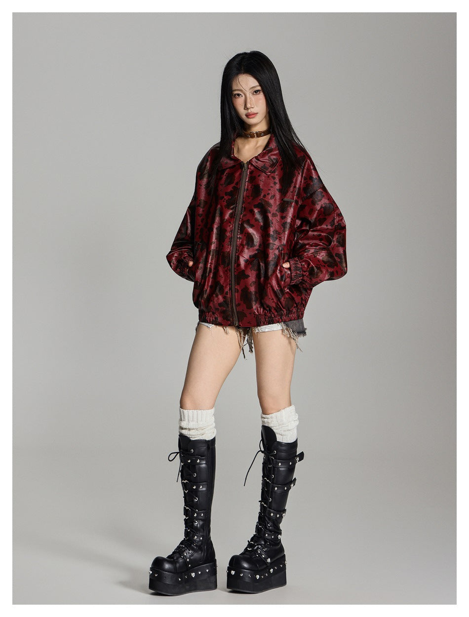 Full-length model wearing a burgundy mottled zip jacket, shorts, white leg warmers and black platform boots.