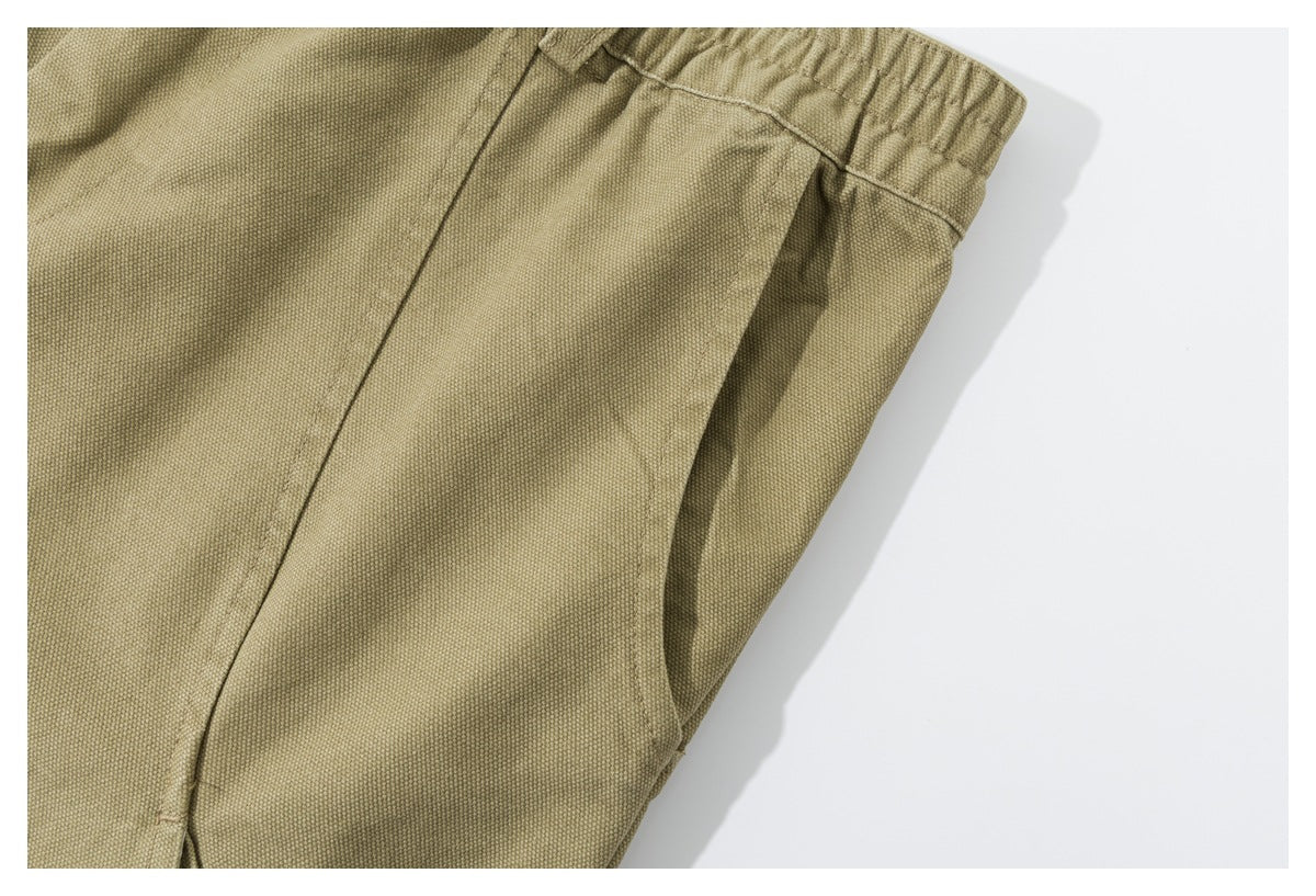 Close-up of a side pocket and seams on the olive-khaki shorts.