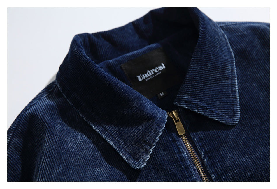 Close-up of the jacket's wide corduroy collar, brass zipper, and sewn-in neck label.