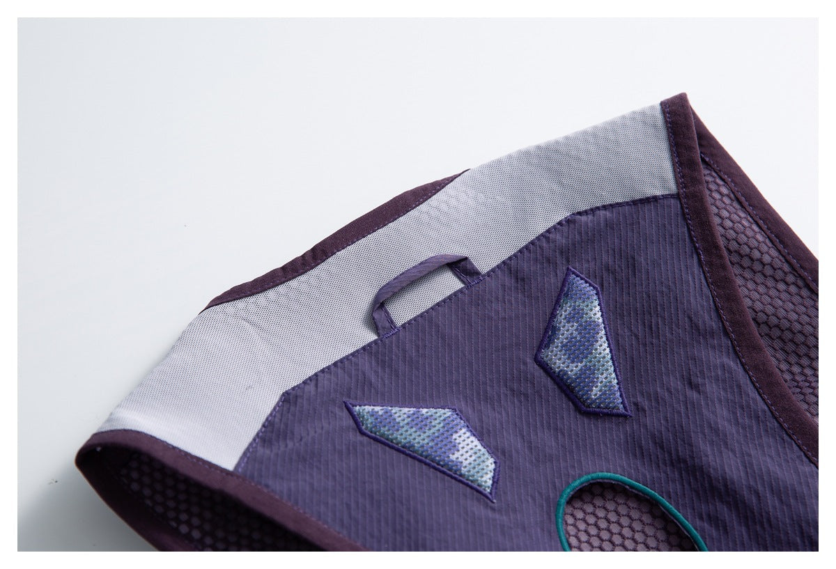 Close-up of a purple backpack panel with gray mesh sections, geometric accents, and a small fabric loop.