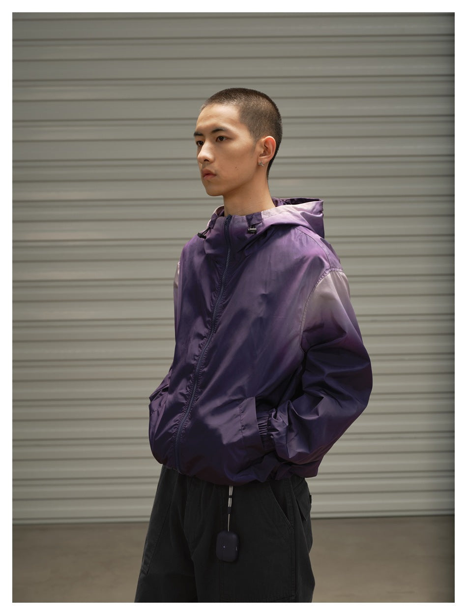 Model wearing a purple hooded zip jacket with elastic cuffs and hem, shown from the front at an angle.