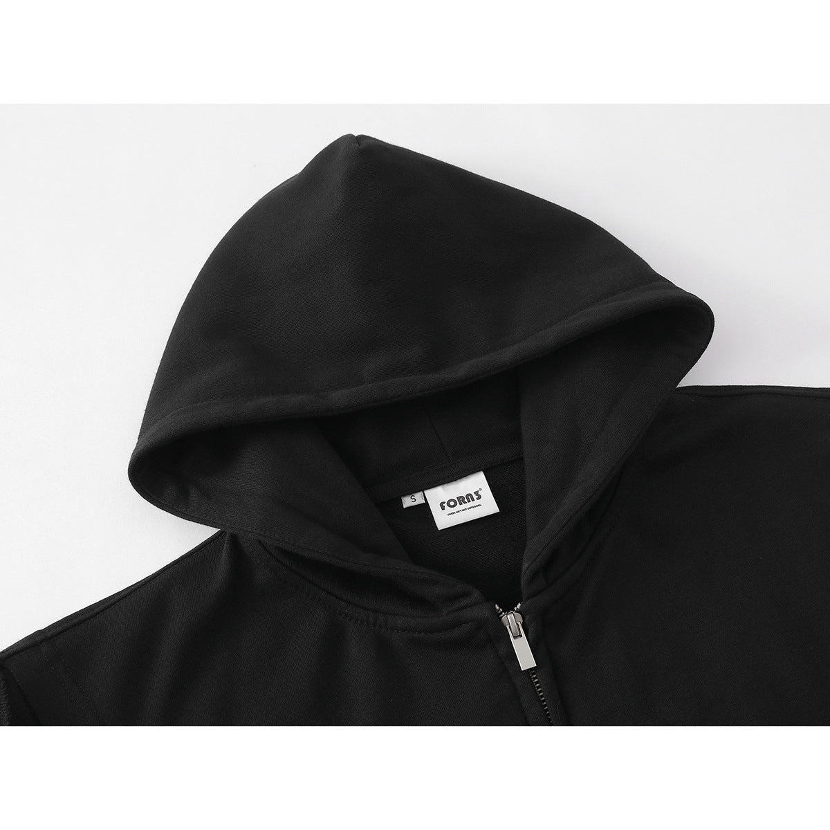 Close-up of a black sleeveless zip hoodie showing the hood, silver zipper, and inner neck label.