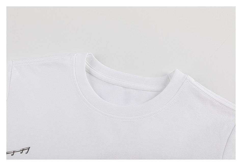 Close-up of the white T-shirt's crew neckline, shoulder seams, and a small musical-note graphic at the edge.