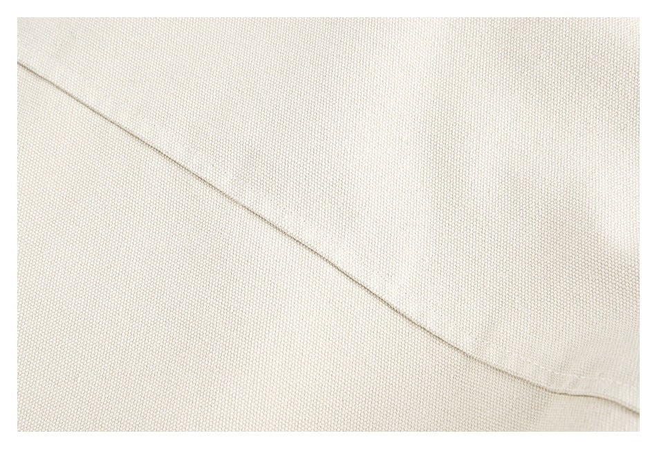 Close-up of a diagonal stitched seam on cream woven fabric.