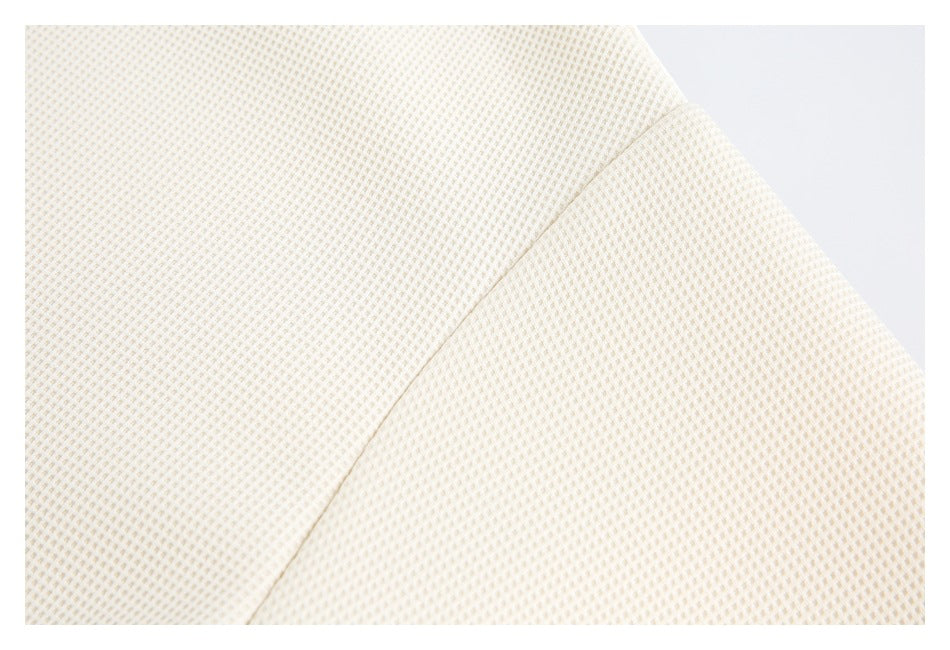 Close-up of the cream knit top's shoulder and sleeve seam.
