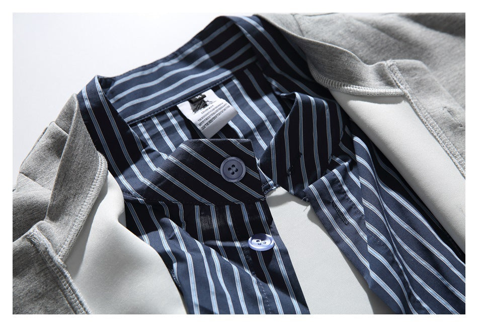 Close-up of the navy striped collar and button placket beneath a gray outer layer.