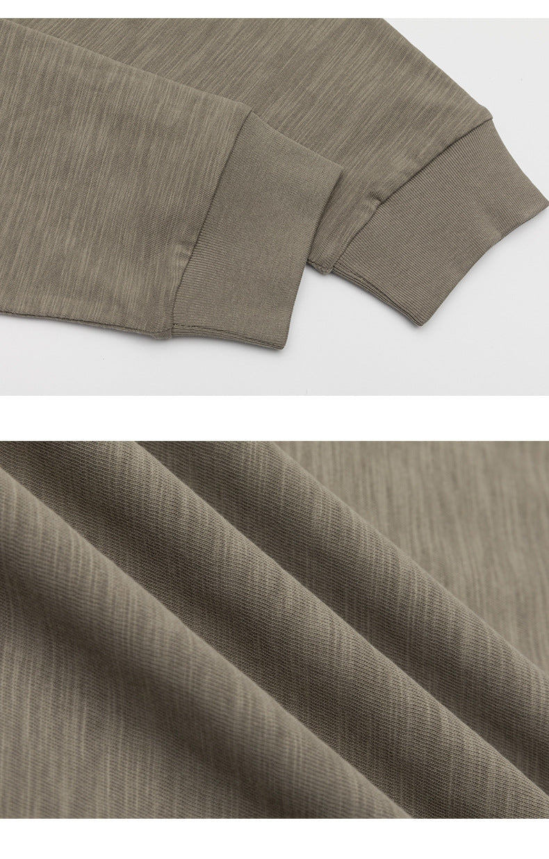 Close-up of a taupe T-shirt sleeve with a ribbed cuff and a view of the fabric texture.