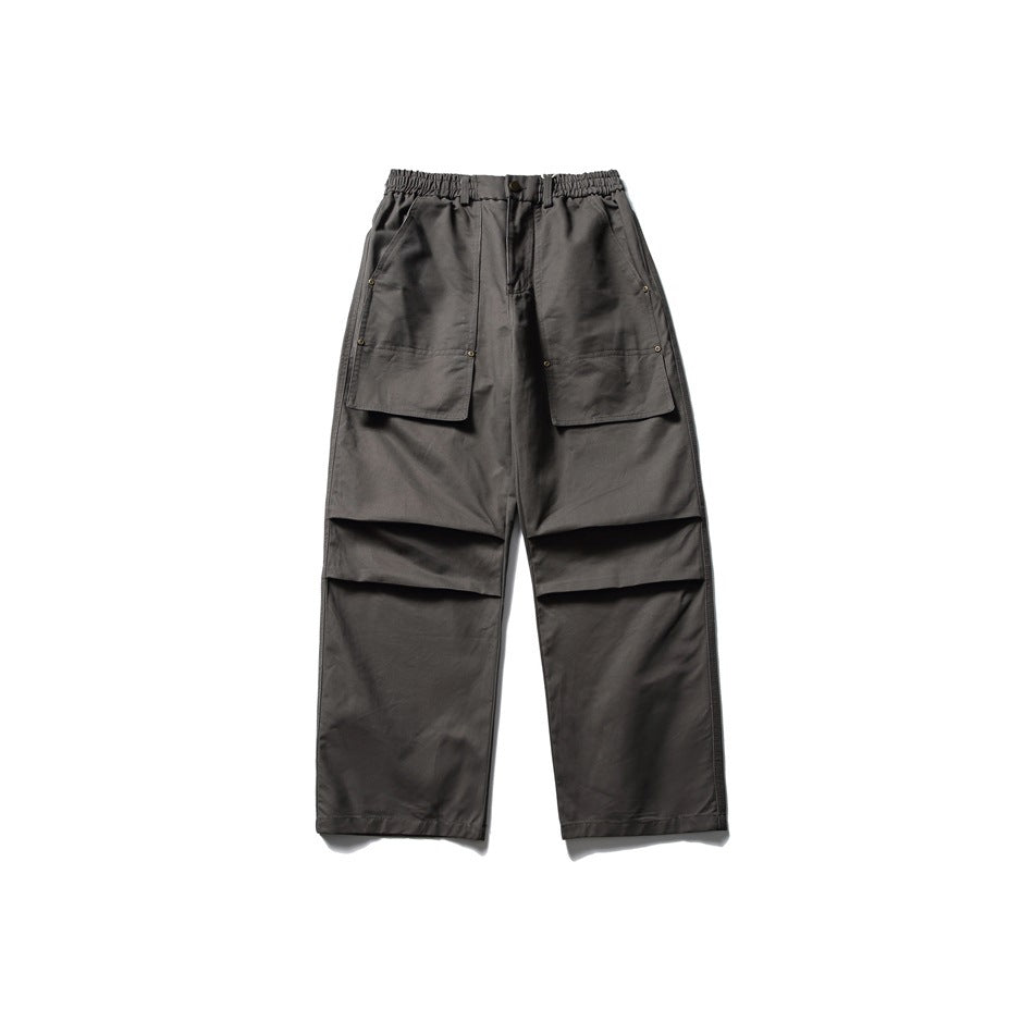 Dark gray wide-leg pants with elastic waist, large front patch pockets and knee pleats, flat front view