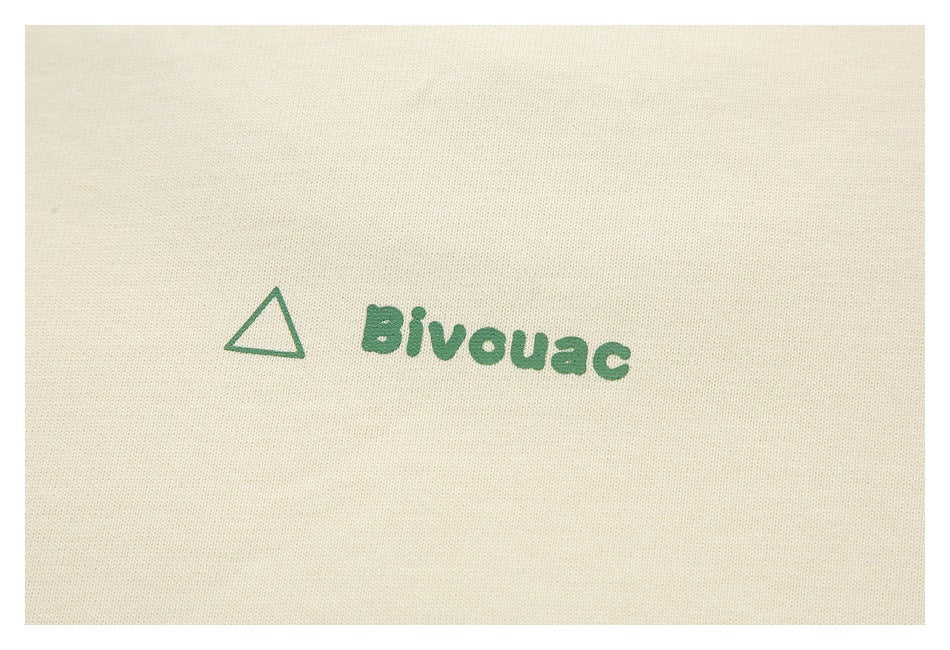 Close-up of a green triangle and Bivouac print on ivory fabric.
