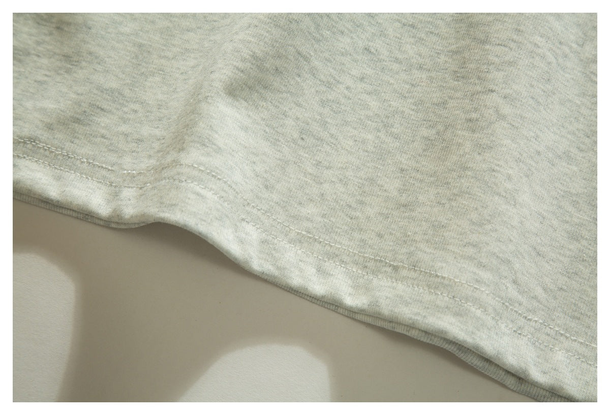 Close-up of a pale heather gray garment hem with parallel stitching.