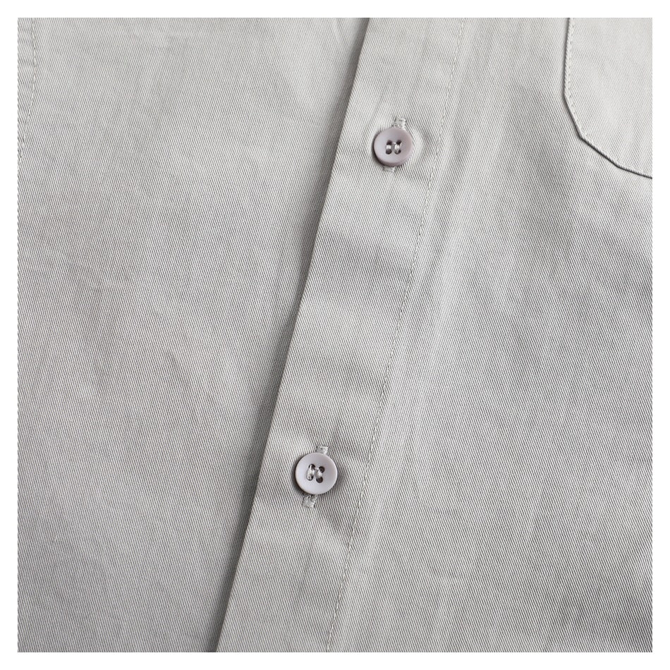 Close-up of two buttons on the light gray shirt's front placket, with part of a chest pocket visible.