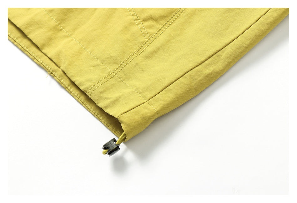 Close-up of the mustard-yellow jacket hem with a cord and toggle adjuster.
