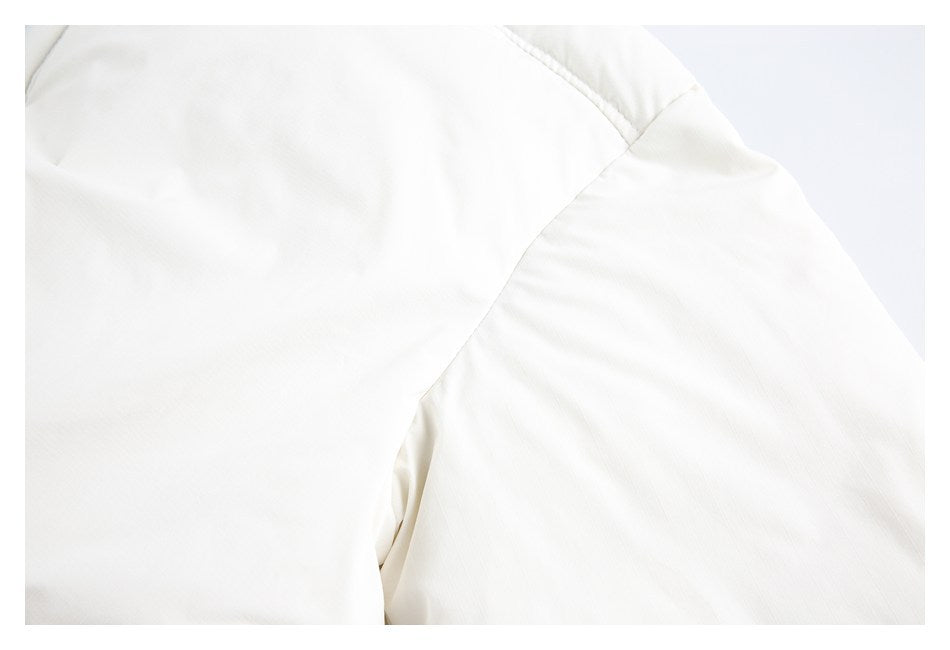 Close-up of curved stitched seams on an ivory garment.
