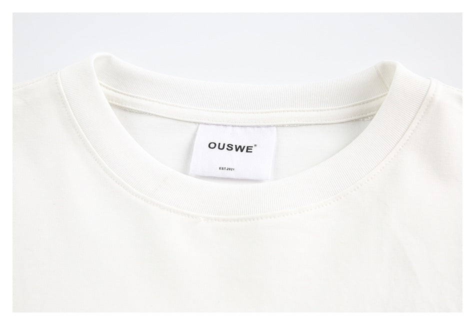 Close-up of a white T-shirt's ribbed crew neckline and OUSWE label.