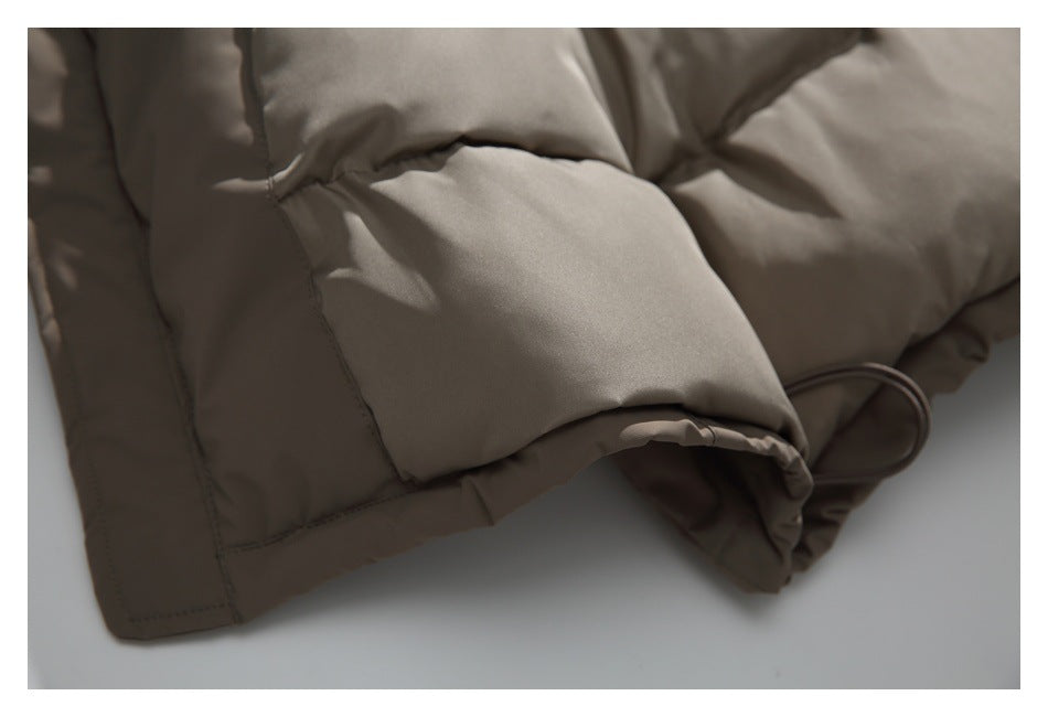 Close-up of a taupe padded jacket sleeve end with a gathered edge and drawcord loop.