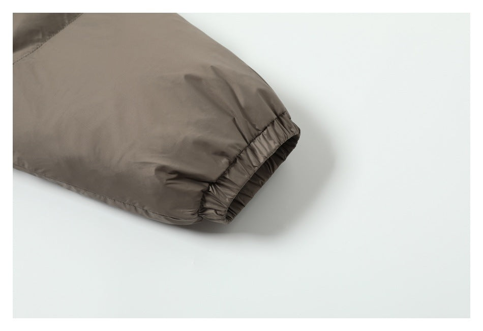 Close-up of a taupe jacket sleeve ending in a gathered elastic cuff.