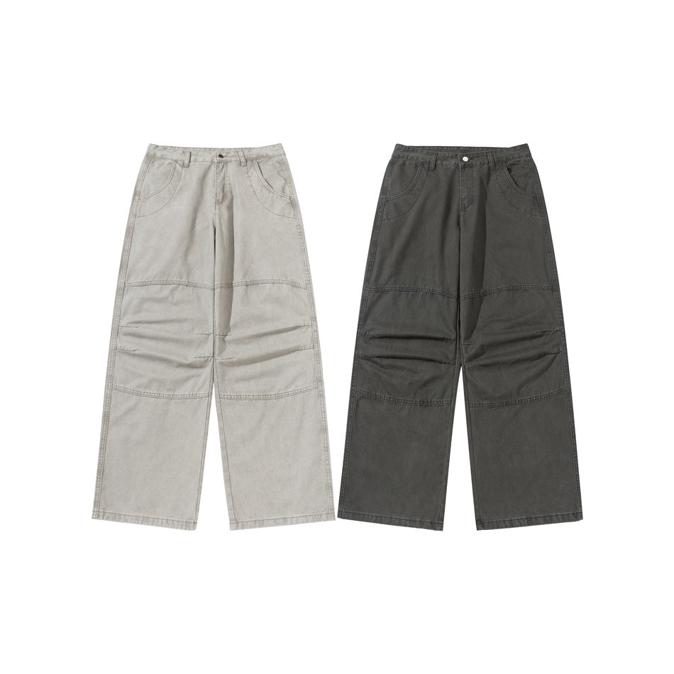 Two pairs of wide-leg pants shown from the front in light gray and charcoal, with curved pockets and knee seams.