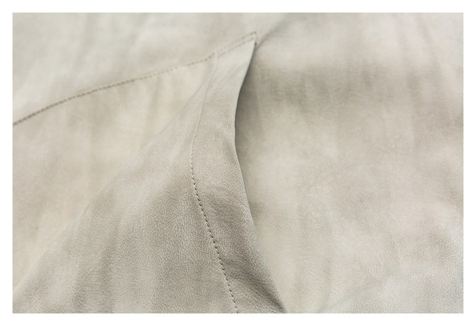 Close-up of the beige shirt's curved pocket edge and visible stitching.