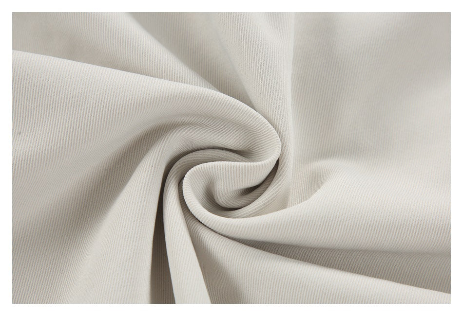 Pale beige garment fabric gathered into a swirl, showing its fine ribbed surface.