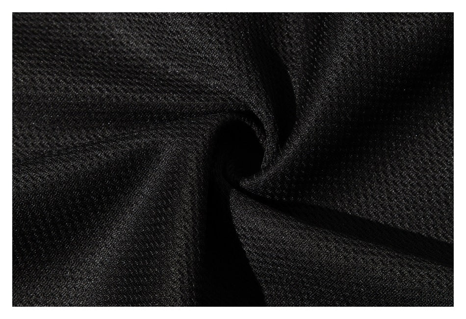 Extreme close-up of black textured garment fabric gathered into folds.