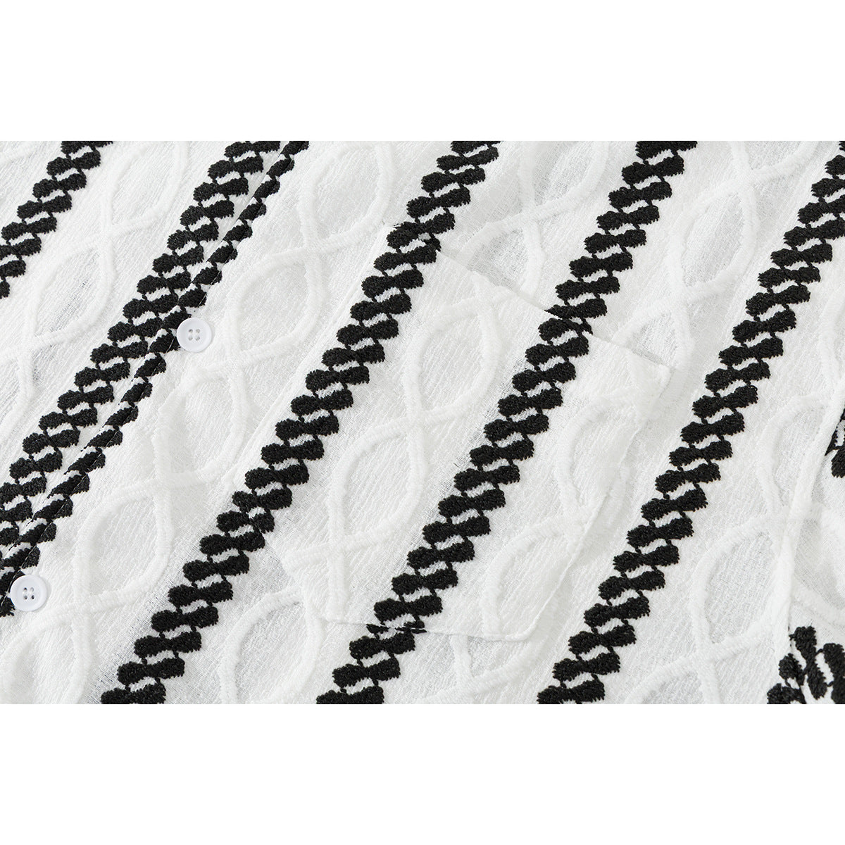 Close-up of white textured shirt fabric with black braided stripes, leaf-like motifs, and white buttons.