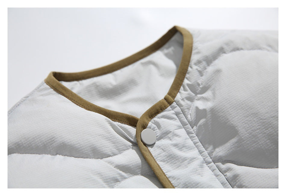 Close-up of the jacket neckline and snap placket, finished with brown trim.