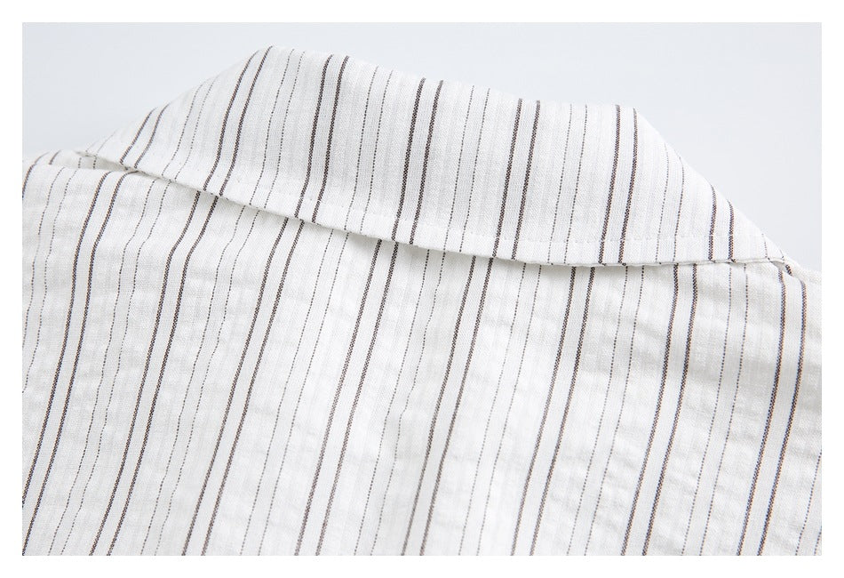 Close-up of the pointed collar and fine dark stripes on a white shirt.