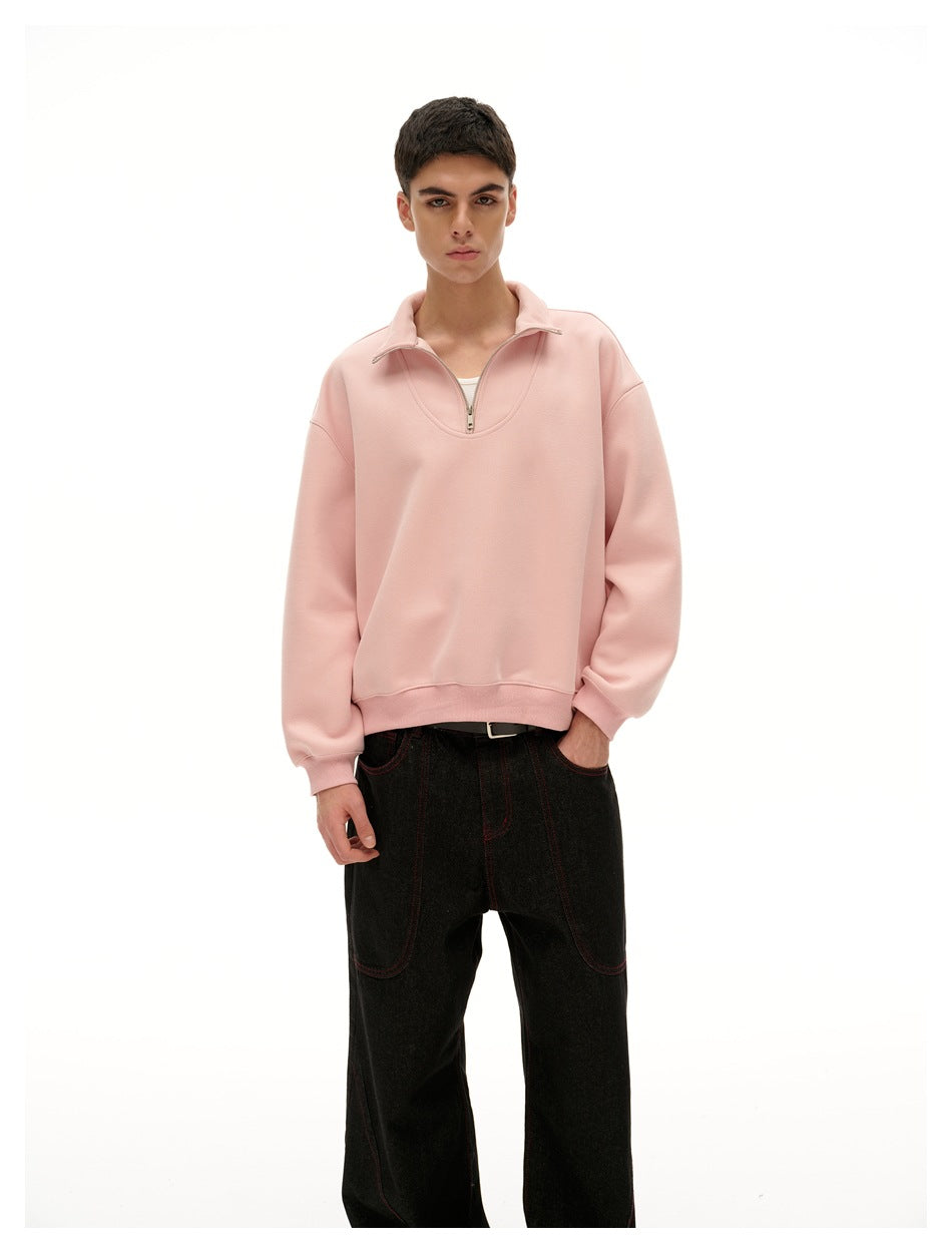 Closer front view of a model wearing a pale pink quarter-zip pullover with a folded collar and ribbed cuffs.