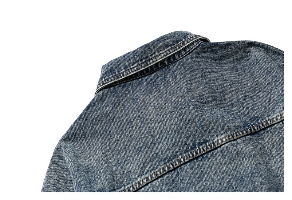 Close-up of the upper back of a mottled blue denim jacket, showing the collar and yoke seams.