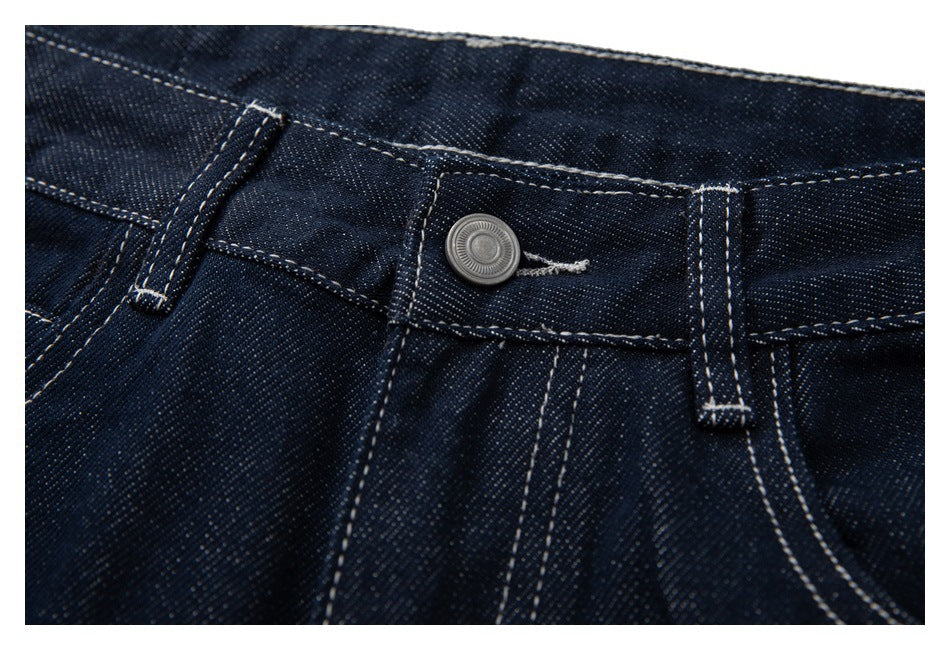 Close-up of the jeans' metal waist button, belt loops and contrast-stitched waistband.