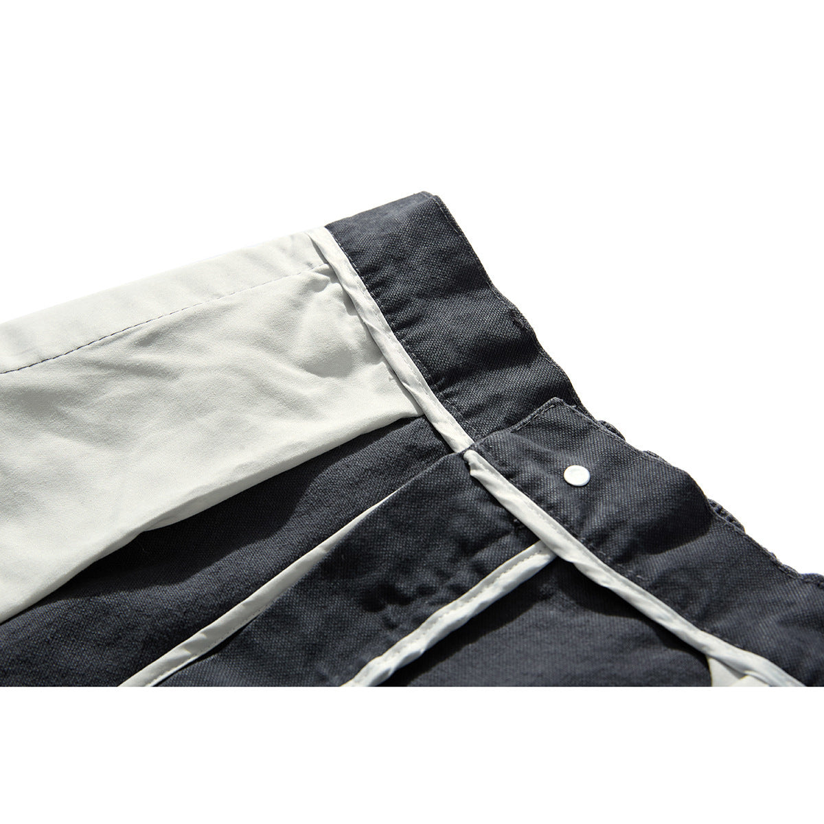 Inside waistband detail of charcoal-gray trousers with pale lining and a button closure.