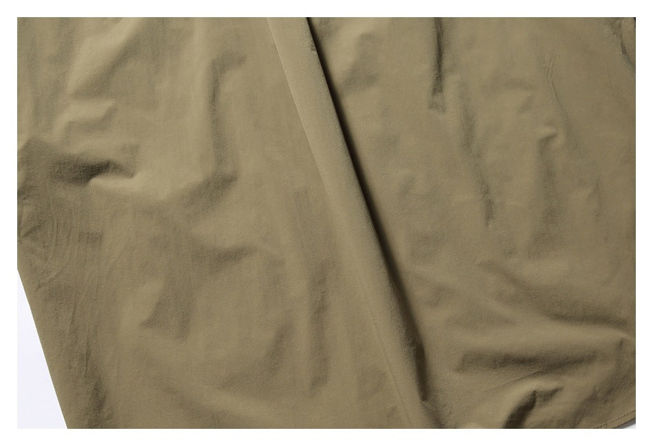Close-up of olive-khaki garment fabric with soft folds and a smooth surface.