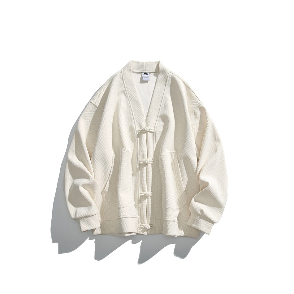 Off-white waffle-textured V-neck cardigan jacket with knotted frog buttons and rounded pockets, flat lay