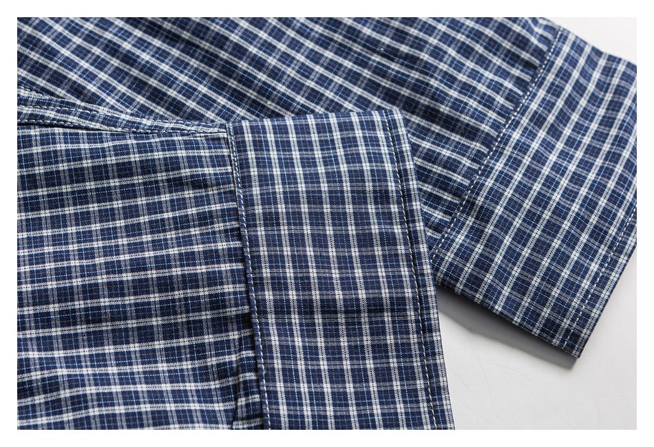 Close-up of the blue plaid shirt's sleeve and buttoned cuff.