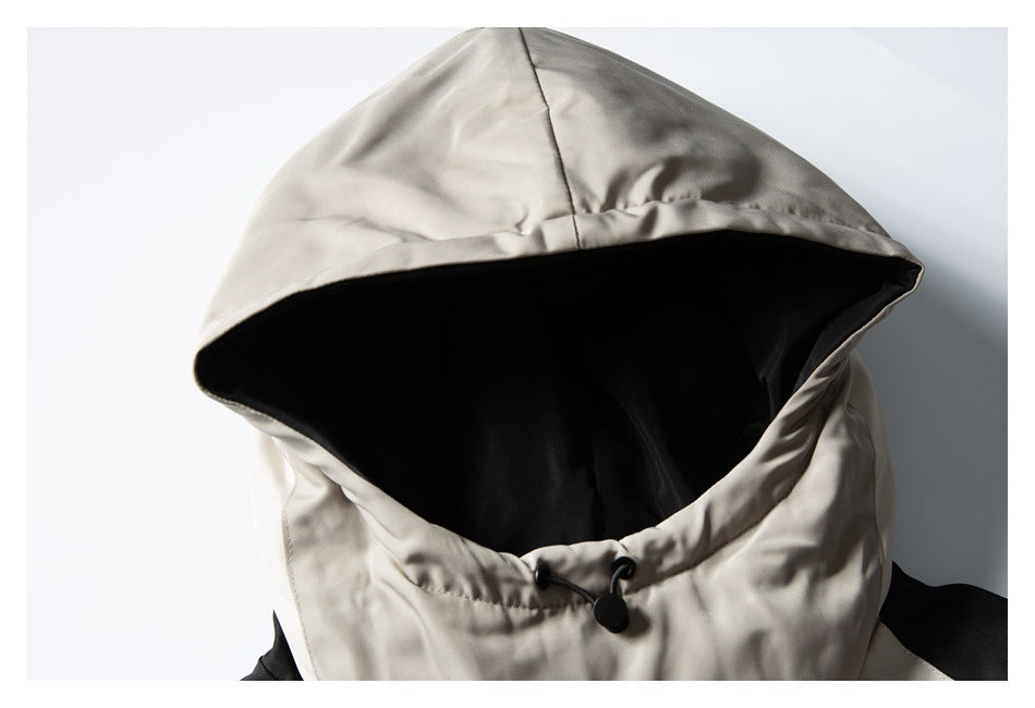 Close-up of a light taupe hood with black lining and a black drawcord adjuster.