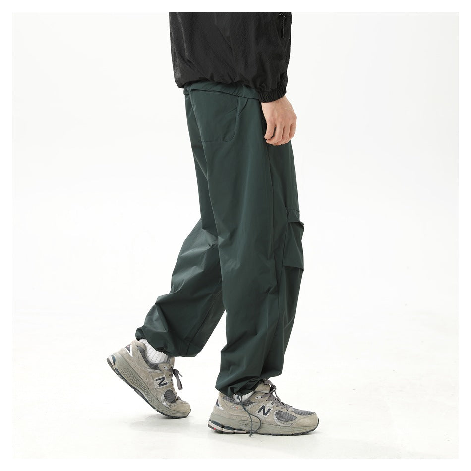 Side and rear view of a model wearing dark green wide-leg cargo pants, showing a back pocket and layered knee panels.