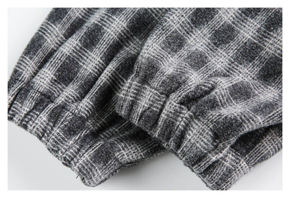 Close-up of folded, stitched edges in charcoal gray plaid fabric.
