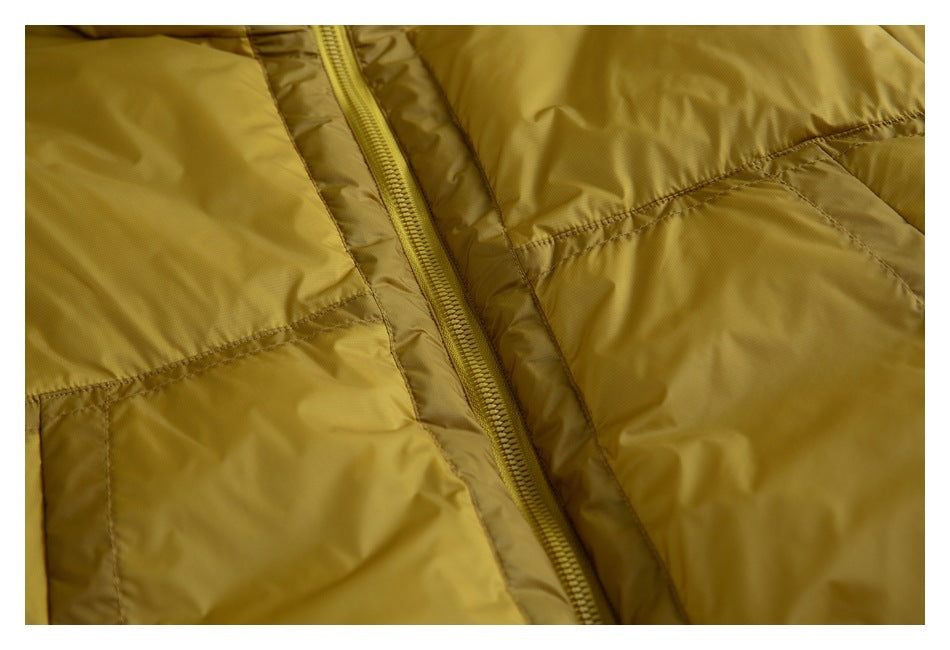 Close-up of the mustard-yellow jacket's front zipper and surrounding stitched panels.