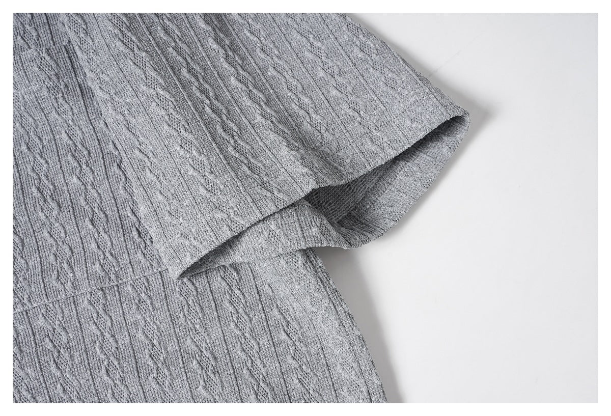 Close-up of the gray knit shirt's sleeve edge and hem stitching.