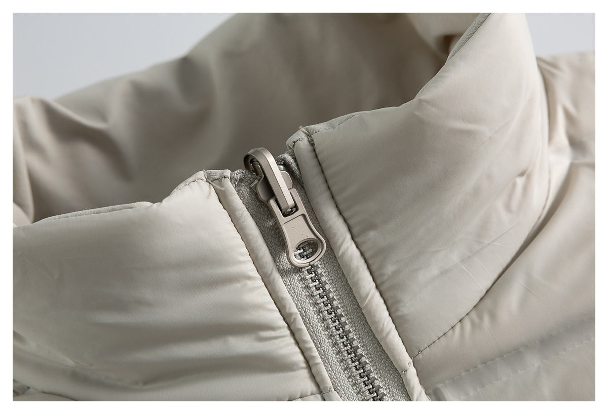 Close-up of the light beige jacket's metallic zipper pull, zipper teeth, and padded collar.