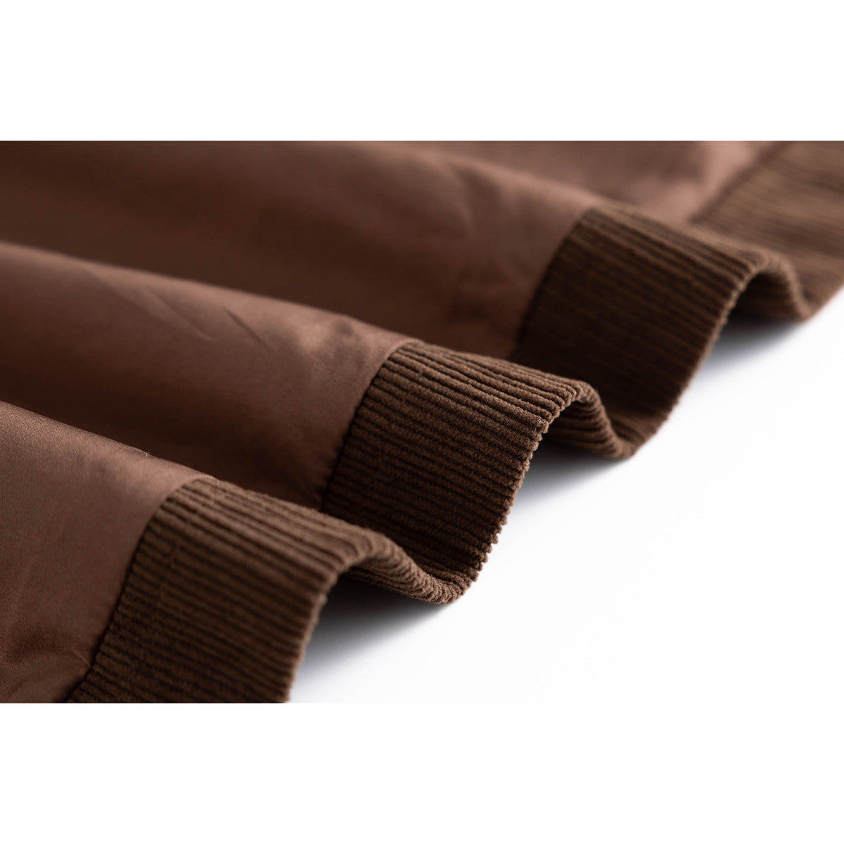 Close-up of brown jacket cuffs showing ribbed trim and smooth brown lining.