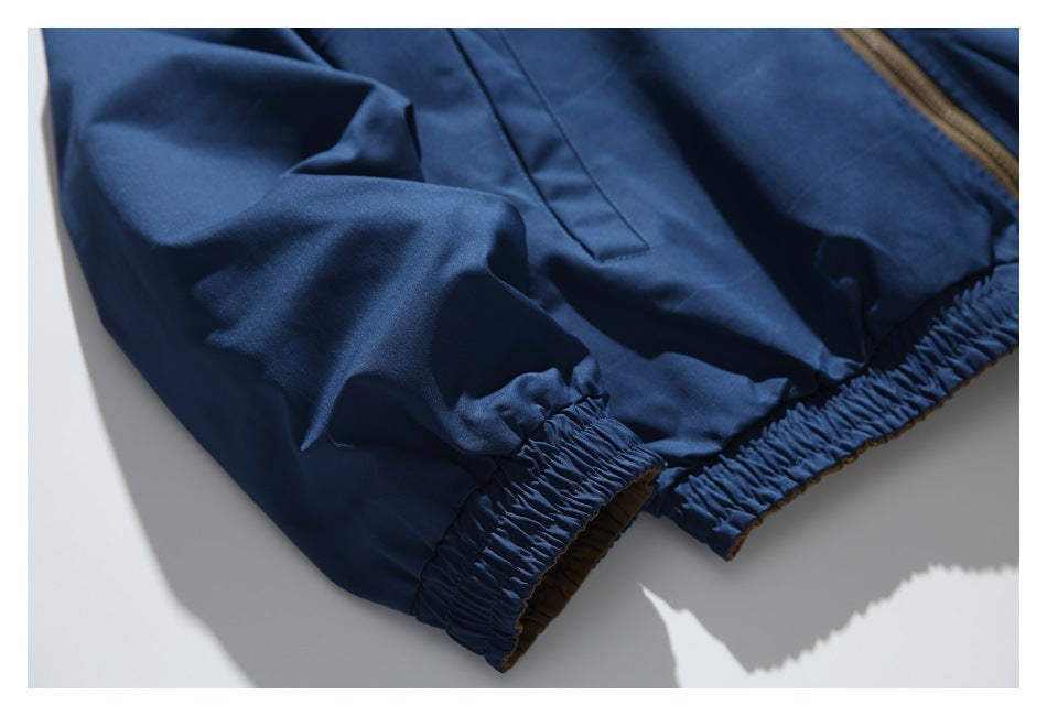 Close-up of a navy garment with gathered elastic edging and a brown zipper trim.