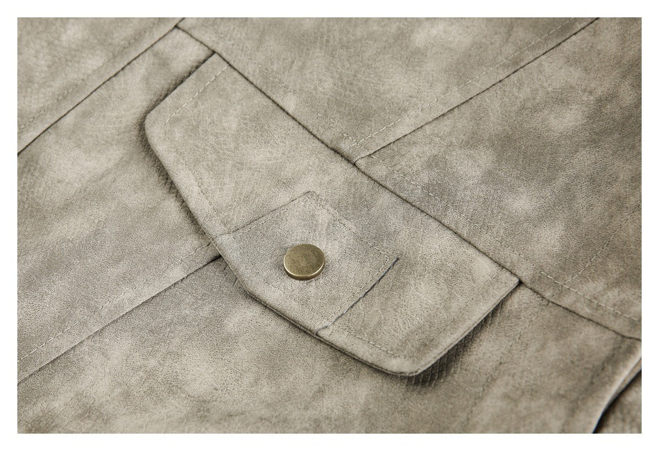 Close-up of a taupe-gray jacket flap with a round brass-tone snap and visible stitching.