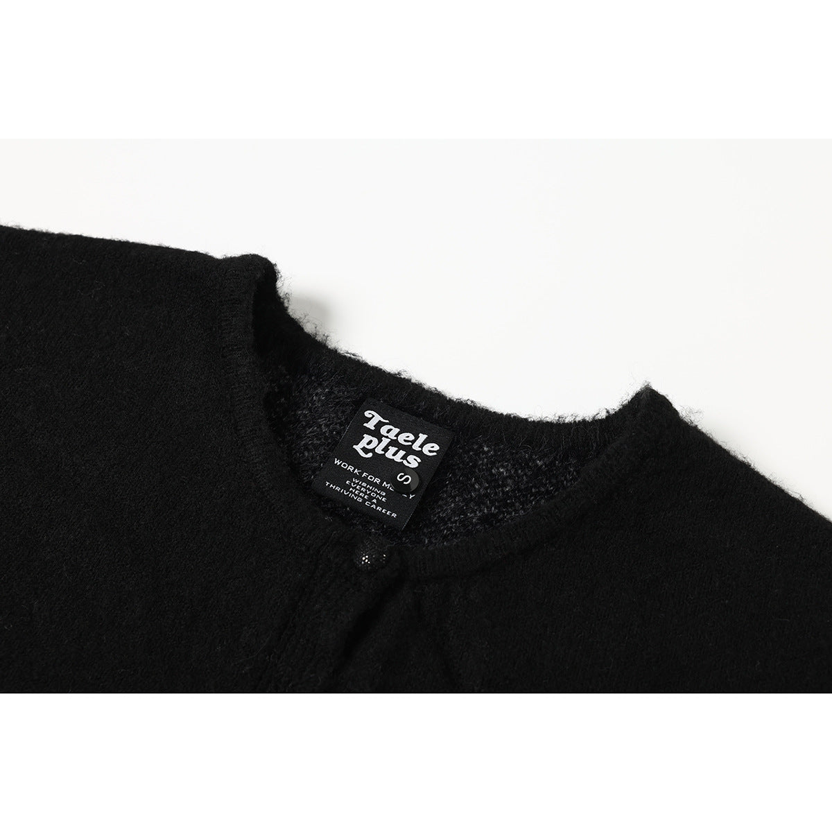 Close-up of a black knit neckline with a sewn black brand and size label.