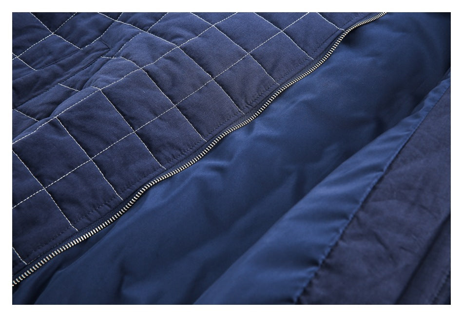 Close-up of the navy quilted garment opened to show its smooth lining and main zipper.