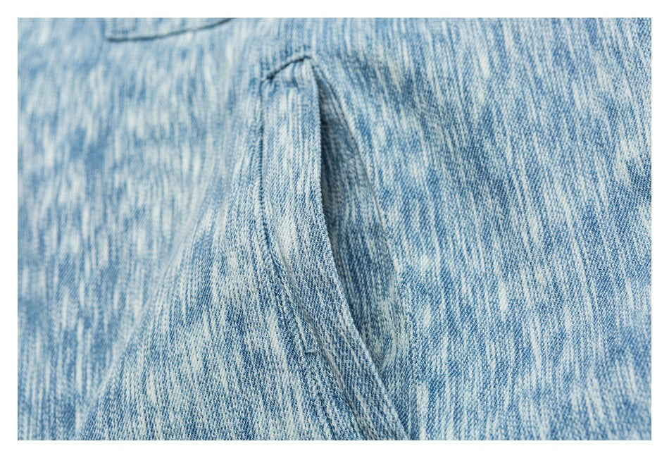 Macro view of the light blue patterned jacket fabric and a curved stitched seam.