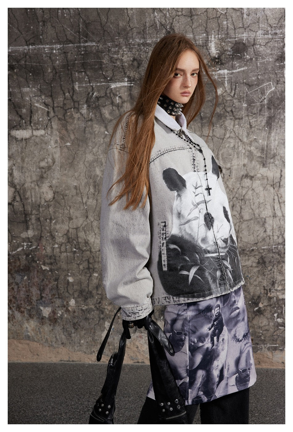 Model wearing a pale gray jacket with a large panda graphic and a purple image-print skirt over black trousers.