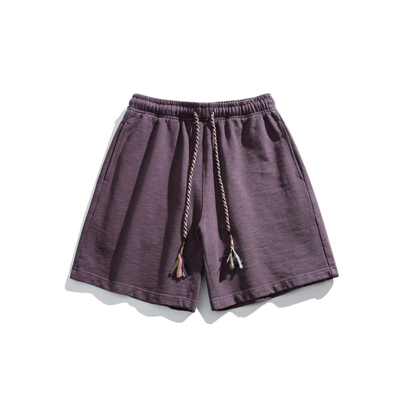 Dusty purple knit shorts flat lay with elastic waistband and braided tassel drawstring